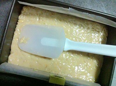 花生牛轧糖,迅速倒入准备好的模具中，用一只干净的刮刀把锅里和勺子上的糖浆刮干净，并把牛轧糖压平整