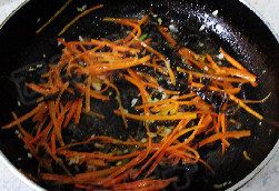 鱼香肉丝,倒入胡萝卜和木耳丝煸炒均匀