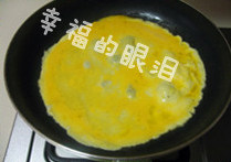 玉子烧,平底锅中加入少量油，油热后倒入鸡蛋液，立刻转小火。转动锅子，使鸡蛋饼摊成圆形。