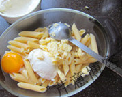 希腊风味焗烤面,在煮熟的意面中趁热加入鸡蛋、2到3大勺白酱和一大把切达奶酪