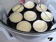 美味蛋挞速成法--【椰丝蛋挞】, 用取物夹夹紧烤盘，平稳的放置在锅内。