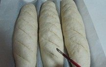 越嚼越香的“核仁葡萄干全麦面包棍”,约40分钟过后， 面包的第二次发酵就完成了， 在面包表面斜划几刀