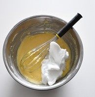  柚子乳酪蛋糕,用电动打蛋器把蛋白打至产生浓稠细密泡沫后，往里加入一半的糖。继续打至蛋白出现明显痕迹后再加入剩下的一半，到蛋白中性发泡时停止搅打。