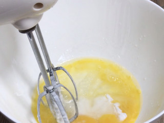 抹茶红豆蛋糕卷,蛋黄中加入剩下的糖粉和玉米油、清水搅拌均匀