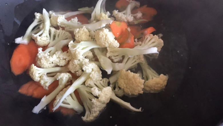 胡萝卜炒花菜,下入花菜胡萝卜焯水，加入少许盐