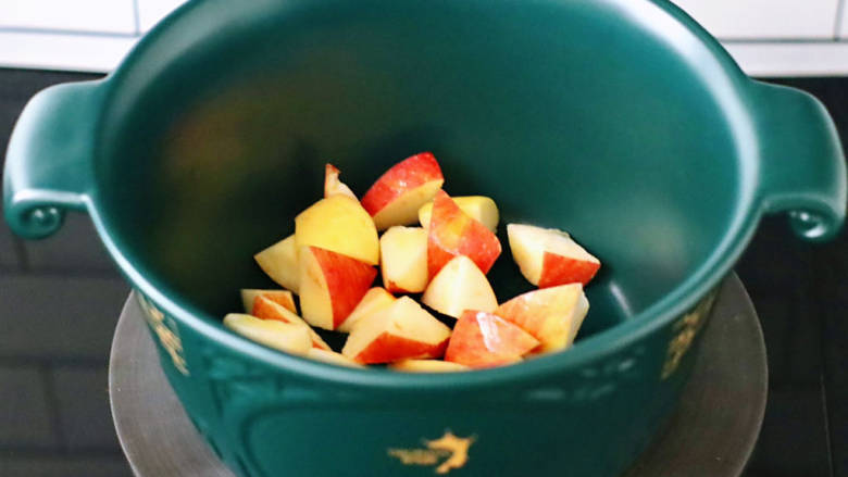 无花果苹果酒酿羹,切好的苹果块放入砂锅里。