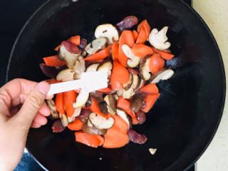 香菇板栗焖饭,加入香菇和胡萝卜，煸炒片刻，撒入盐调味