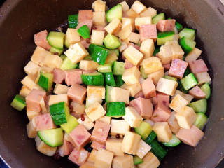 黄瓜烧豆腐,放入黄瓜、午餐肉翻炒均匀。