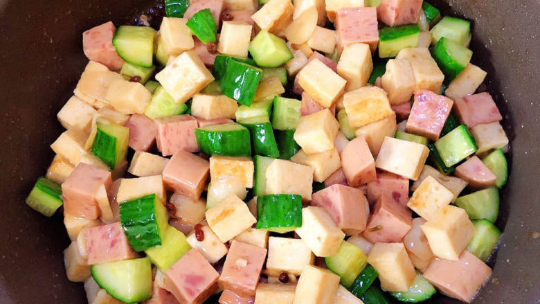 黄瓜烧豆腐,放入黄瓜、午餐肉翻炒均匀。