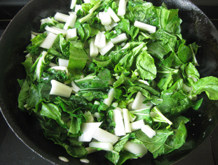 青菜烧芋头,锅里热油，倒入青菜煸炒至变软。