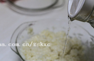 蔓越莓芝心糯米球,此时的米饭表层还是半生的，取出后用筷子打松，再加适量清水