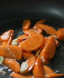 三色素开花,另锅将油烧到五成热，蒜籽切成薄片，煸出香味，下胡萝卜煸熟