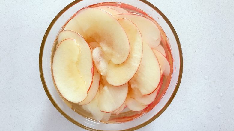 宝宝辅食：好吃又健康的水果片,准备一个大碗，装一碗清水，挤入半个<a style='color:red;display:inline-block;' href='/shicai/ 595'>柠檬</a>汁搅拌，然后将切好的苹果片放入，浸泡15-20分钟。
》这一步也可以省去，对成品口感影响不大，不浸泡烤完后苹果片颜色会变深，浸泡足够时间烘烤后颜色比较好看。
》小芽因为时间关系，只泡了5分钟，所以成品依旧变色了哈。
