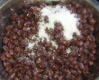 山药红豆糕,红豆用水煮的，即便控干水分也还是会比较湿，我们加入糖以后在炒锅中炒一会儿，把水分炒干，就变成了蜜豆。