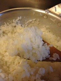 剩饭做米糕,用勺子搅拌米饭，使其均匀受热并能吸收到水分，直到每粒米看起来都吸饱水很柔软的状态。