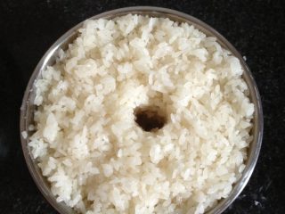自制醪糟,将拌好的糯米放入用开水烫过的容器，把米稍压一下，中间掏个洞，将剩余的酒曲倒入小洞里