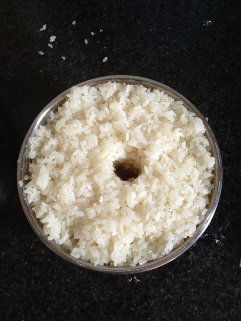 自制醪糟,将拌好的糯米放入用开水烫过的容器，把米稍压一下，中间掏个洞，将剩余的酒曲倒入小洞里