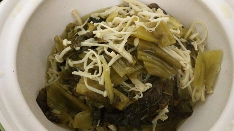 酸汤肥羊煲,捞出酸菜和金针茹放入砂锅（或大的餐具）中。