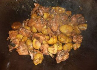 板栗焖鸡,加入板栗和水，盖上锅盖，焖至水分将干时，加入适量的盐炒匀，撒上葱粒即可上碟。