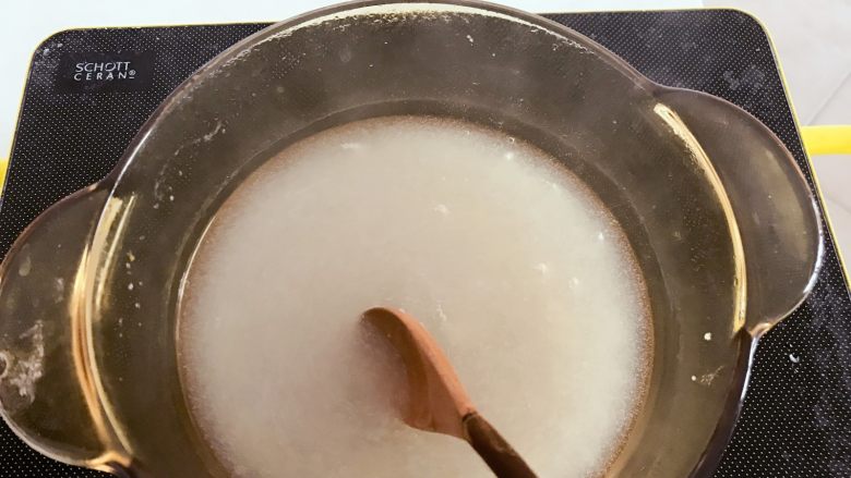 宝宝辅食：橘子酪&橘酪圆子,锅中倒入200ml清水，等水烧到微热后，把水淀粉倒入，一边倒一边用勺子搅拌，搅拌成均匀没有硬块。