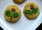 椰香红薯小饼,醒好的面团揉一揉，取一小块压成饼，取红枣片，香菜叶略装饰