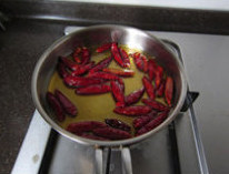香辣鲈鱼,小锅中加入大约2大勺炸鱼用的油，小火慢慢爆香干朝天椒