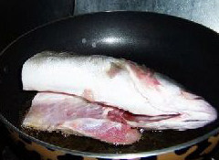 红烧鲈鱼,油热后把鱼放入油锅煎制