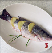 清蒸鲈鱼,将葱打成结、姜切片，在鱼身开口处塞上姜片，鱼肚子塞上葱结腌制30分钟以上