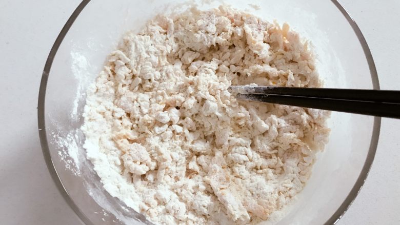 宝宝辅食：南瓜豆沙包,把南瓜泥，融化好的酵母倒入100g面粉中，用刮刀或筷子搅拌成絮状。
