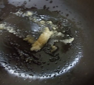栗子红烧猪尾,炒锅放入适量的花生油，加入砂糖，待砂糖部分熔化