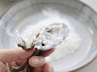 家常炒螃蟹,盘中倒入适量面粉，把切面位置放里面蘸一下，轻轻抖掉多余面粉。