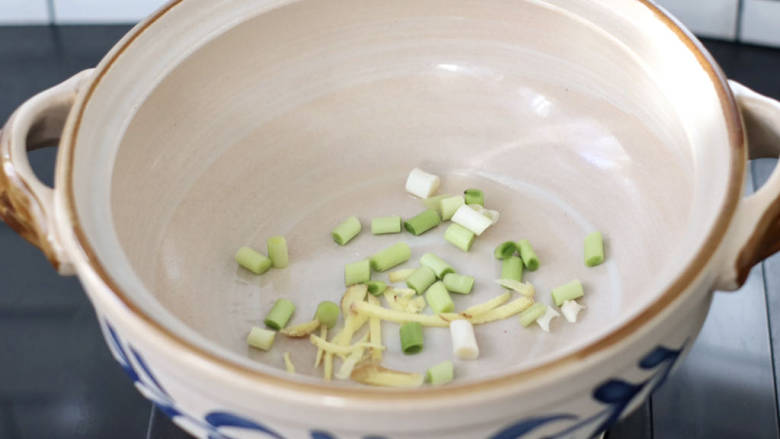 排骨豆腐砂锅,砂锅底部放入蒜末和姜丝。