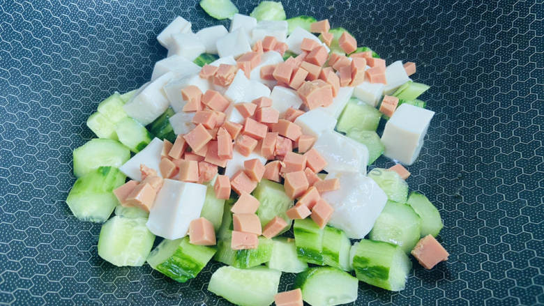 黄瓜烧豆腐,放入黄瓜和火腿丁翻炒一下，再放入豆腐