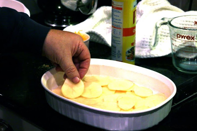 冬日温暖烩菜—芝士烩土豆片,将一半的土豆片整齐码放入烤碗中，把半锅奶酪酱倒在土豆的上。再码放剩下土豆片，然后倒入剩下的奶酪酱即可。