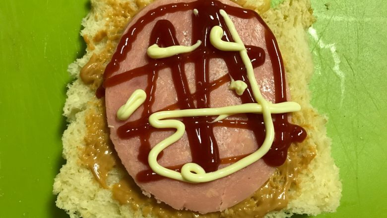 爱心早餐三明治,放上火腿再抹些<a style='color:red;display:inline-block;' href='/shicai/ 4856'>沙拉酱</a>和番茄酱。