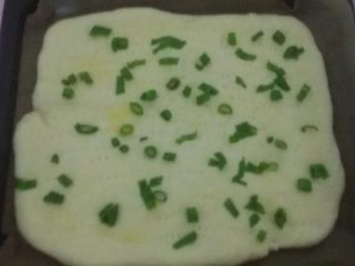 肉松面包卷,发酵好的面片上涂上鸡蛋液，撒上香葱碎，最好是干葱，如果没有就用现成的葱叶代替，并用叉子叉些小孔。
