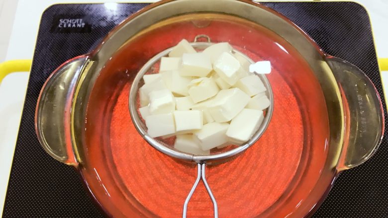 宝宝辅食：南瓜豆腐虾皮煲-8M+,蒸南瓜的同时，将内脂豆腐划成小块，放在筛网中，放入沸水中焯水下，这一步也可以省略哈，有些宝宝不喜欢豆腐的生味儿，焯水下会更好些。