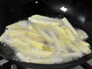 香辣干锅兔,锅中热油，倒入控干水份的土豆条，炸至金黄色。