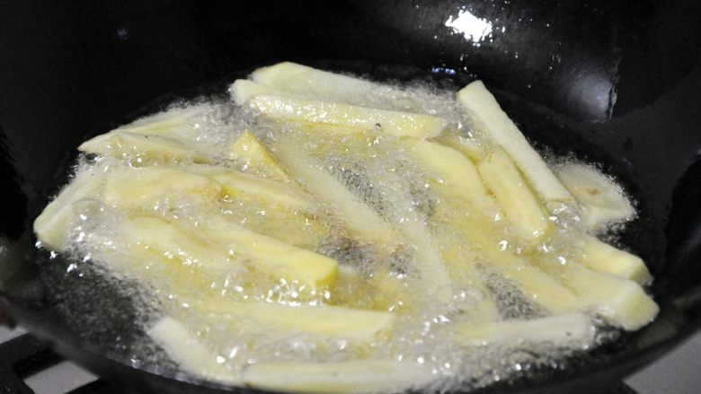 香辣干锅兔,锅中热油，倒入控干水份的土豆条，炸至金黄色。