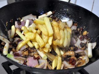 香辣干锅兔,倒入提前炸过的土豆条，继续翻炒。