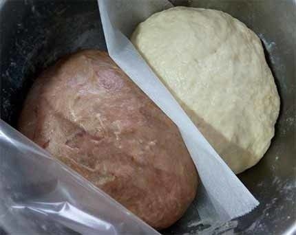 丑丑泰迪熊奶油包,1.面包体所有材料（可可粉除外）揉匀成团，平分成2份（1份约185g），其中1份加入可可粉揉匀，将2种颜色的面团一起放入盆中，面团间用烘焙纸