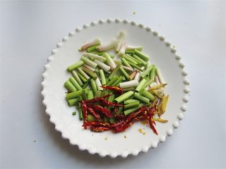 腊肉蒜香卷心菜,将青蒜去除青叶部分切段、红干椒对半切开，生姜切丝或切丁备用