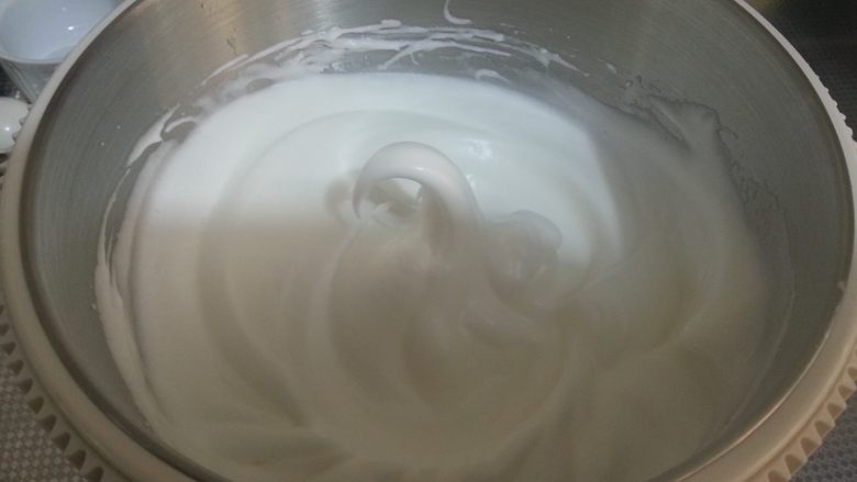 烘焙基础——戚风蛋糕,将蛋白打至湿性发泡（九分发），提起打蛋头，蛋白会出现较长向下弯曲的状态。