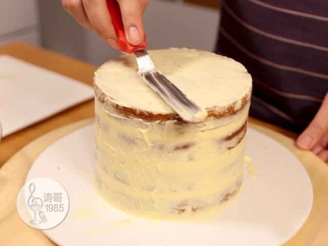 瑞士奶油霜 - 彩虹抹面蛋糕,15、然后用小抹刀把每层填充突出来的奶油霜均匀抹在整个蛋糕的表面，使蛋糕的表面覆盖上一层薄薄的奶油霜，这么做是为了固定蛋糕表面的蛋糕渣
