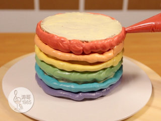 瑞士奶油霜 - 彩虹抹面蛋糕,21、一边旋转蛋糕一边把彩色奶油霜均匀挤到蛋糕侧面，你可以根据自己的喜好来做造型，单色、双色交叉、多色或渐变等都可以