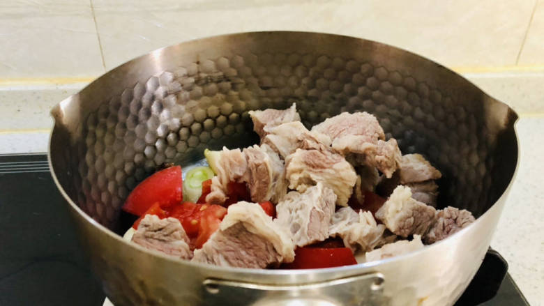 红焖牛肉煲,放入西红柿、牛腩翻炒均匀。