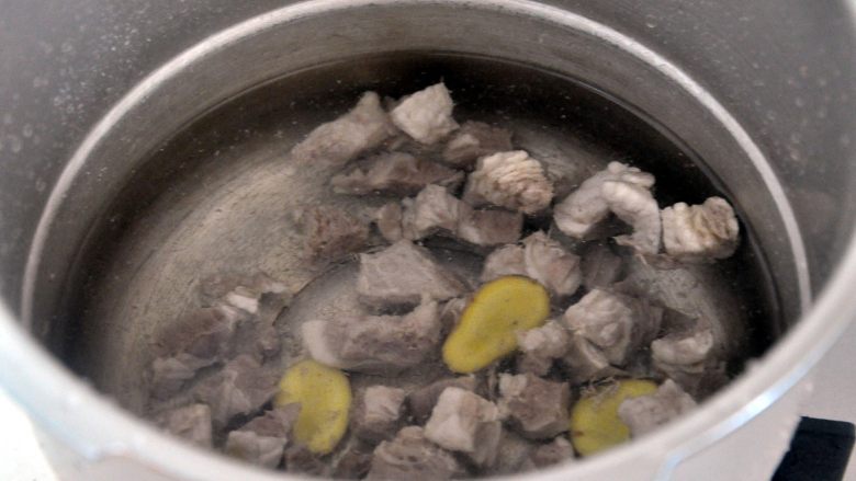 罗宋汤, 将焯过水的牛腩，放入高压锅中，倒入冷水，放上几片姜，盖上盖子压20分钟，这样会相对比较省时。