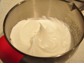 日式豆乳盒子蛋糕,砂糖分3次加入到蛋白中，蛋白打至湿性9分发的状态（如图，提起打蛋头会呈现小弯钩）。
