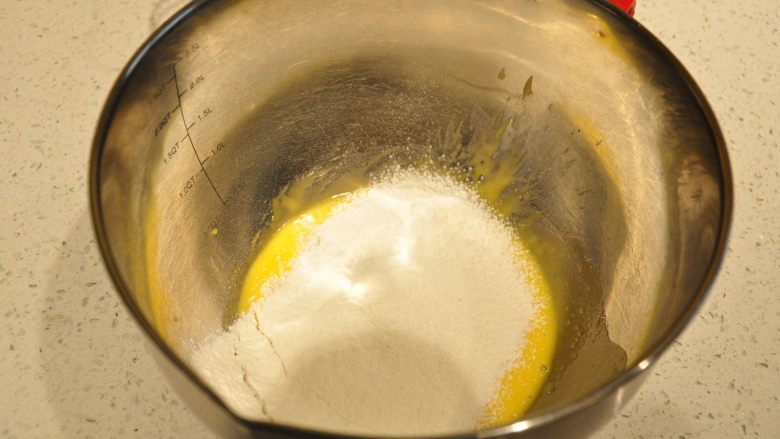 日式豆乳盒子蛋糕,将低筋面粉全部过筛加入到蛋黄糊中。