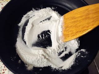 奶黄冰皮月饼,现在来炒糕粉，将称好的糯米粉，倒入平底锅，小火翻炒。